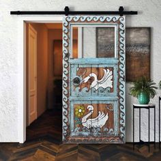 an old wooden door with swans painted on it