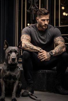 a man with tattoos sitting next to a dog