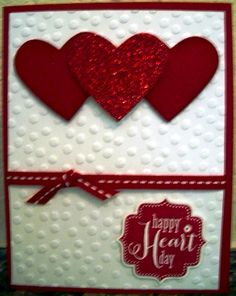 two red hearts are on top of a white card