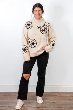 Natural mock neck sweater with black stitched flowers This whimsical Stitch Of Flowers Natural Sweater is perfect for when you want to feel fashionable and comfortable. The cozy natural knit and mock neck make sure you stay warm when the temperature drops, while the black stitched flowers add a touch of romantic style. Wear this sweater for an effortlessly chic look, whether going out for a special Fall event or spending the day with friends. Relaxed fit First model is 5'3" wearing a small Secon Cozy Long Sleeve Sweater With Floral Embroidery, Cozy Winter Sweater With Floral Embroidery, Cream Sweater With Floral Embroidery For Fall, Beige Floral Embroidered Sweater For Fall, Winter Black Sweater With Floral Print, Cream Floral Embroidered Sweater For Fall, Cream Floral Embroidery Sweater For Fall, Black Floral Print Sweater For Winter, Stitched Flowers