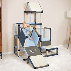 a baby sitting in a blue and white play set with stairs, slides and climbing bars