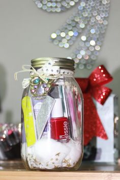 a jar filled with lots of different items on top of a wooden table next to a christmas tree