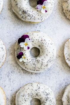 there are many donuts with white frosting and flowers on them