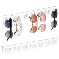 four pairs of sunglasses hanging on a rack with eyeglasses attached to the wall