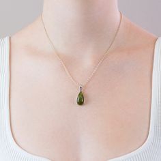 This Green Tourmaline necklace is a dazzling, unique green stone with a powerful positive energy that radiates from whoever's wearing it. The softness and clarity of the green, along with the elegance of the gemstone's rough cut, will lend a touch of understated glam to any outfit. This beautiful Green tourmaline crystal necklace set in 925 sterling silver has the ability to turn negative energy into good energy, encouraging creativity while also attracting success, wealth, and abundance. Green Emerald Drop Gemstone Necklace, Emerald Teardrop Gemstone Necklace, Green Jade Teardrop Pendant Jewelry, Emerald Drop Necklace For May Birthstone, May Birthstone Emerald Drop Necklace, Elegant Green Crystal Necklace With Round Pendant, Elegant Green Round Pendant Crystal Necklace, Elegant Healing Necklace With May Birthstone, Elegant May Birthstone Necklace For Healing