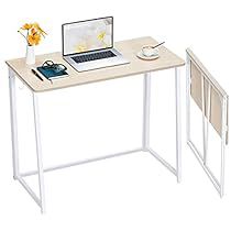 a computer desk with a laptop on it and a flower in a vase next to it