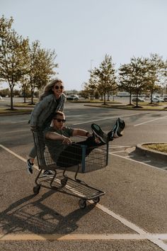 two people are riding in a shopping cart