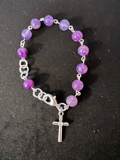 This beautiful lightweight rosary bracelet is sure to add a colorful accent to any wardrobe!  The bracelet is made with purple beads, cross, aluminum jump rings and wire. Bracelets are approximately 7 1/2" in length when open from the top to the bottom.  Also, bracelet is adjustable since it is made with some rings.  Clasp is super easy to use. If you do require a larger or smaller size, just send me a message and I can add more or remove jump rings at no added charge. All of bracelets are handm Adjustable Beaded Purple Rosary Bracelet, Adjustable Purple Beaded Rosary Bracelet, Spiritual Nickel-free Purple Beaded Bracelets, Adjustable Purple Rosary Bracelet With 8mm Beads, Adjustable Purple Rosary Bracelet, Handmade Adjustable Purple Rosary, Cross-shaped Rosary Bracelet With 8mm Beads, Adjustable Purple Spiritual Rosary Bracelet, Adjustable Beaded Rosary Bracelet With Crucifix