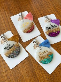 four personalized ornament with tassels on them sitting on a table