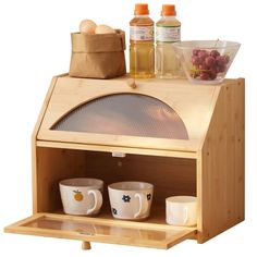 a small wooden oven with two mugs and bowls on it's counter top