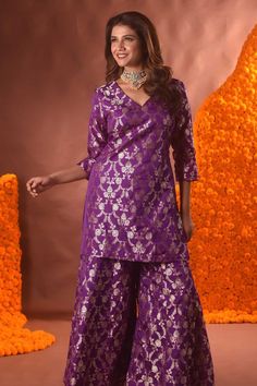 Purple banarasi silk kurta with floral pattern. Comes with sharara.
Components: 2
Type Of Work: Floral
Neckline: V Neck
Sleeve Type: Three quarter
Fabric: Banarasi silk
Color: Purple
Other Details: 
Note: Necklace worn by the model is not for sale.
Occasion: Mehendi and Haldi - Aza Fashions Designer Jamawar Palazzo Set For Diwali, Festive Purple Brocade Set, Designer Brocade Sets With Straight Kurta, Designer Brocade Straight Kurta Sets, Festive Straight Kurta Set In Brocade, Purple Banarasi Silk Set For Eid, Festive Brocade Set With Straight Kurta, Designer Bollywood Brocade Palazzo Set, Designer Brocade Sharara For Festive Occasions