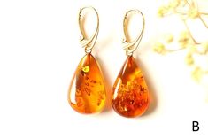 The earrings of Baltic amber in rich honey colour will not betray your expectations. It is one of the most popular colours of Baltic amber. Executed in the shape of a drop, they will perfectly match to any outfit. These lightweight, elegant, sophistically sparkling earrings with a spangle inside are an irresistible piece of jewellery that you will love wearing every day. It is a genuine, natural and unique piece of jewellery created by nature, so you will feel special on every occasion. Delight Orange Baltic Amber Teardrop Jewelry, Handmade Amber Teardrop Earrings, Baltic Amber Teardrop Earrings For Gift, Baltic Amber Teardrop Earrings As Gift, Amber Dangle Earrings In Baltic Amber, Gift Amber Drop Earrings, Amber Teardrop Earrings Gift, Amber Teardrop Earrings As A Gift, Amber Teardrop Drop Earrings For Gift