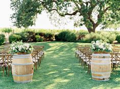 an outdoor ceremony set up with wooden barrels and flowers