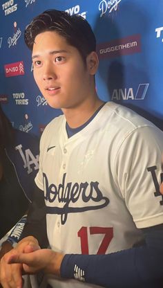 the baseball player is signing autographs for fans to sign on his jersey and give him an autograph