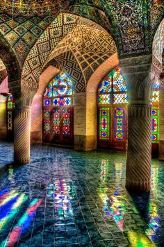 colorful stained glass windows and pillars in an ornate building with tiled floors, arches and columns