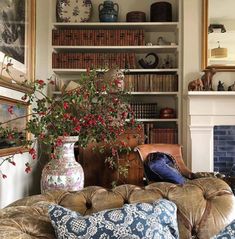 a living room filled with furniture and a fire place covered in books next to a fireplace