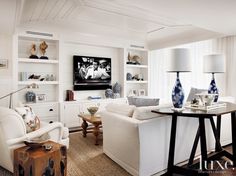 a living room filled with furniture and a flat screen tv mounted to the side of a wall