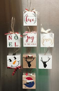 christmas ornaments are hanging on the wall in front of a refrigerator with magnets that say joy, joy, joy to the world