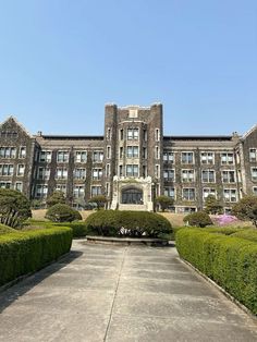 a large building with many windows and bushes around it