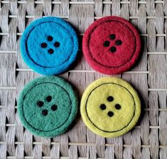 three different colored buttons sitting on top of a wicker table