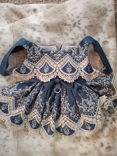 a blue and white dress laying on top of a bed