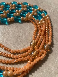 Double Strand Waist Bead – a radiant creation meticulously crafted with warm tan glass crystal seed beads, complemented by larger, vibrant blue glass seed bead accents. This double-strand waist bead not only embodies the warmth of a sunlit horizon but also radiates a harmonious charm, offering a captivating and adjustable fit that transcends beauty and symbolism. 🌅 Tan Glass Crystal Seed Beads - Radiant Warmth: Toulepleu is adorned with a radiant array of tan glass crystal seed beads, capturing Multi-strand Czech Glass Beaded Necklace, Bohemian Multi-strand Beaded Waist Beads, Bohemian Multi-strand Waist Beads, Bohemian Style Multi-strand Beaded Waist Beads, Multi-strand Polished Czech Glass Beads, Colorful Multi-strand Czech Glass Beads, Polished Czech Glass Multi-strand Beads, Orange Multi-strand Beaded Necklaces For Beach, Orange Multi-strand Polished Beaded Necklaces