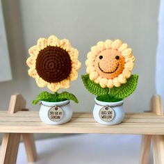 two crocheted sunflowers sitting on top of each other in small pots