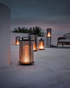 a group of lit candles sitting on top of a cement floor