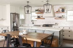 a kitchen with white cabinets and wooden table