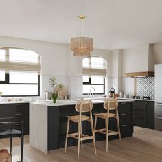 two stools are in the middle of a kitchen with black cabinets and white countertops