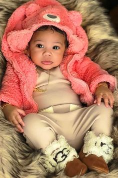 a baby wearing a pink coat and hat