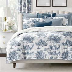 a bed with blue and white comforters in a bedroom