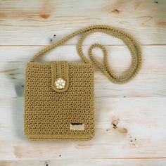 a crocheted purse sitting on top of a wooden floor next to a string