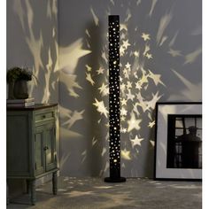 a tall black pole with stars on it in the middle of a room next to a wall