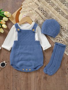 a baby's outfit, hat and booties on a table