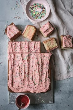 a cake with pink frosting and sprinkles next to a bowl of ice cream