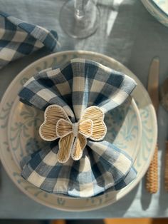 a blue and white plate with a bow napkin on it next to utensils