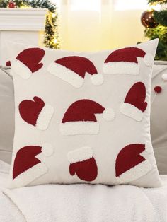 a red and white pillow with santa hats on it