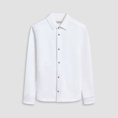 Made from a luxurious soft-touch knit fabric, this performance shirt jacket offers exceptional comfort and style. It features a point collar, full snap closure, ribbed cuffs, zippered side pockets, and sleek nylon trimming. Combining practicality with modern sophistication, this shirt jacket is a great choice for both casual and activewear. Modern Tailored Tops With Spread Collar, Tailored Long Sleeve Casual Tops, Casual White Outerwear With Spread Collar, Elegant Button-up Outerwear With Placket, Modern Tailored Long Sleeve Tops, Casual Tailored Tops With Lapel Collar, Modern Tailored Button-up Top, Modern Business Tops With Button Cuffs, Modern White Outerwear With Concealed Placket