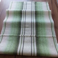 a green and white striped table cloth on a wooden floor