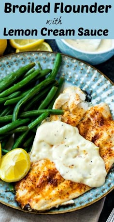 grilled chicken breast with lemon cream sauce on a blue plate next to green beans