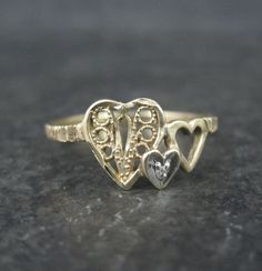 This beautiful, dainty, vintage filigree heart ring is 10k yellow gold with a tiny genuine diamond. The face of this ring measures 5/16 of an inch north to south. Size: 6 Marks: JCM, 10K Condition: Excellent Heirloom Heart Promise Ring, Heirloom Engraved Heart Ring, 14k Gold Heirloom Heart Promise Ring, Heirloom 14k Gold Heart Promise Ring, Vintage Promise Jewelry For Valentine's Day, Vintage Heart Ring For Promise, Vintage 14k Gold Heart-shaped Rings, Vintage Double Heart 14k Gold Jewelry, Vintage 14k Gold Double Heart Jewelry