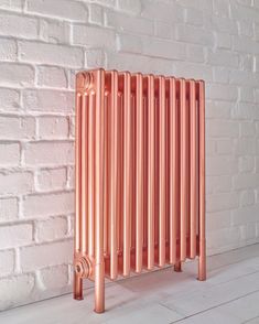 a copper radiator against a white brick wall