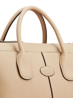 Find TOD'S Di Leather Tote Bag on Editorialist. This Tod's tote bag is crafted from calfskin with a pebbled texture. The bag features a debossed logo to the front, two rolled top handles, an adjustable detachable shoulder strap, and a top zip fastening. The main compartment contains an internal zip-fastening pocket. This tote bag is small in size and has a top handle. Luxury Beige Pebbled Leather Shoulder Bag, Beige Pebbled Leather Shoulder Bag With Top Handle, Beige Pebbled Leather Satchel With Double Handle, Beige Pebbled Leather Top Handle Shoulder Bag, Beige Pebbled Leather Top-handle Satchel, Beige Pebbled Leather Satchel Bag, Beige Pebbled Leather Top Handle Satchel, Soft Pebbled Leather Bag With Top Handle, Soft Pebbled Leather Top Handle Bag