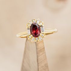 Product Details Ring Style: The "Cleopatra" is an art deco-style oval garnet women's engagement ring with diamond accents. Many other center stone options are available upon request. Center Stone: 7x5mm Oval Garnet Materials: 14K gold engagement ring featuring a garnet center stone and 1/5 CTW accent diamonds Customizable: Because each ring is handcrafted to order, we can customize yours using unique materials, gemstones, or design features, often without any added cost! We can even use personal Garnet Ring Vintage, Oval Solitaire Engagement Ring, Garnet Engagement Ring, Antique Engagement Rings Vintage, Staghead Designs, Detailed Ring, Handcrafted Rings, Garnet Rings, Gold Wedding Band