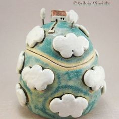 a blue and white ceramic object with clouds on it