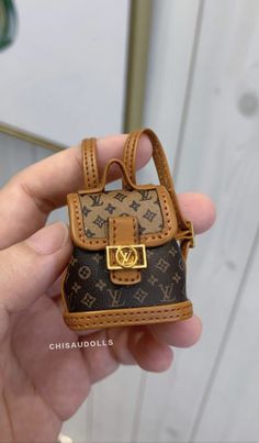 someone is holding a miniature handbag in their left hand and it looks like they have been made out of real louis vuitton