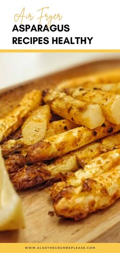 grilled asparagus and potatoes on a wooden cutting board with lemon wedges