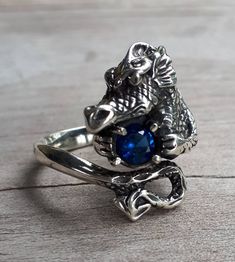 dragon ring sterling silver Blue cubic zircon It weights 8-9 gms (depending on the size) She measures 25mm (1 '')from top of his head to his tail IF your size is not listed pls convo me I CAN MAKE HIM WITH ANY STONE.. FOR ANY SIZE FINGER I have this one listed in 9ct gold also Gothic Silver Crystal Ring With Gemstone, Gothic Sterling Silver Crystal Ring As Gift, Gothic Sterling Silver Crystal Ring For Gift, Gothic Sterling Silver Rings For Gift, Gothic Silver Ring With Gemstone, Gothic Style Silver Ring With Gemstone, Collectible Dragon Design Jewelry Ring, Collectible Dragon Design Ring, Gothic 925 Stamped Ring