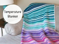 a crocheted blanket sitting on top of a couch next to a lamp